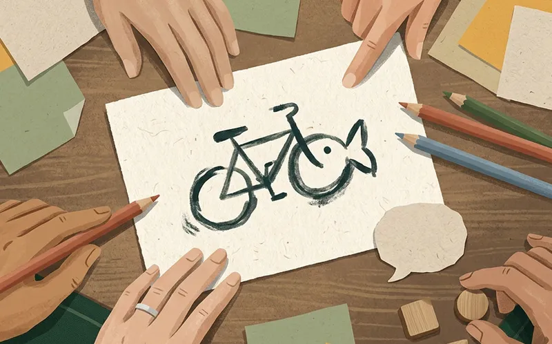 A sketch that is half bicycle, half fish, surrounded by hands and colored pencils.